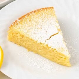 a slice of Italian Lemon Cake sprinkled with powdered sugar on a plate