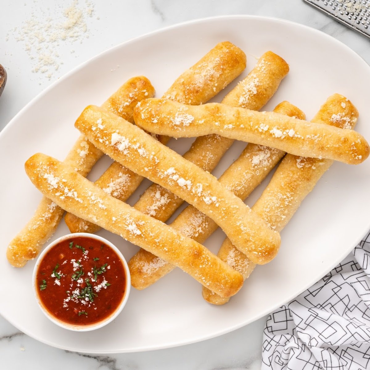 a plate of Crazy Bread with a bowl of marinara sauce
