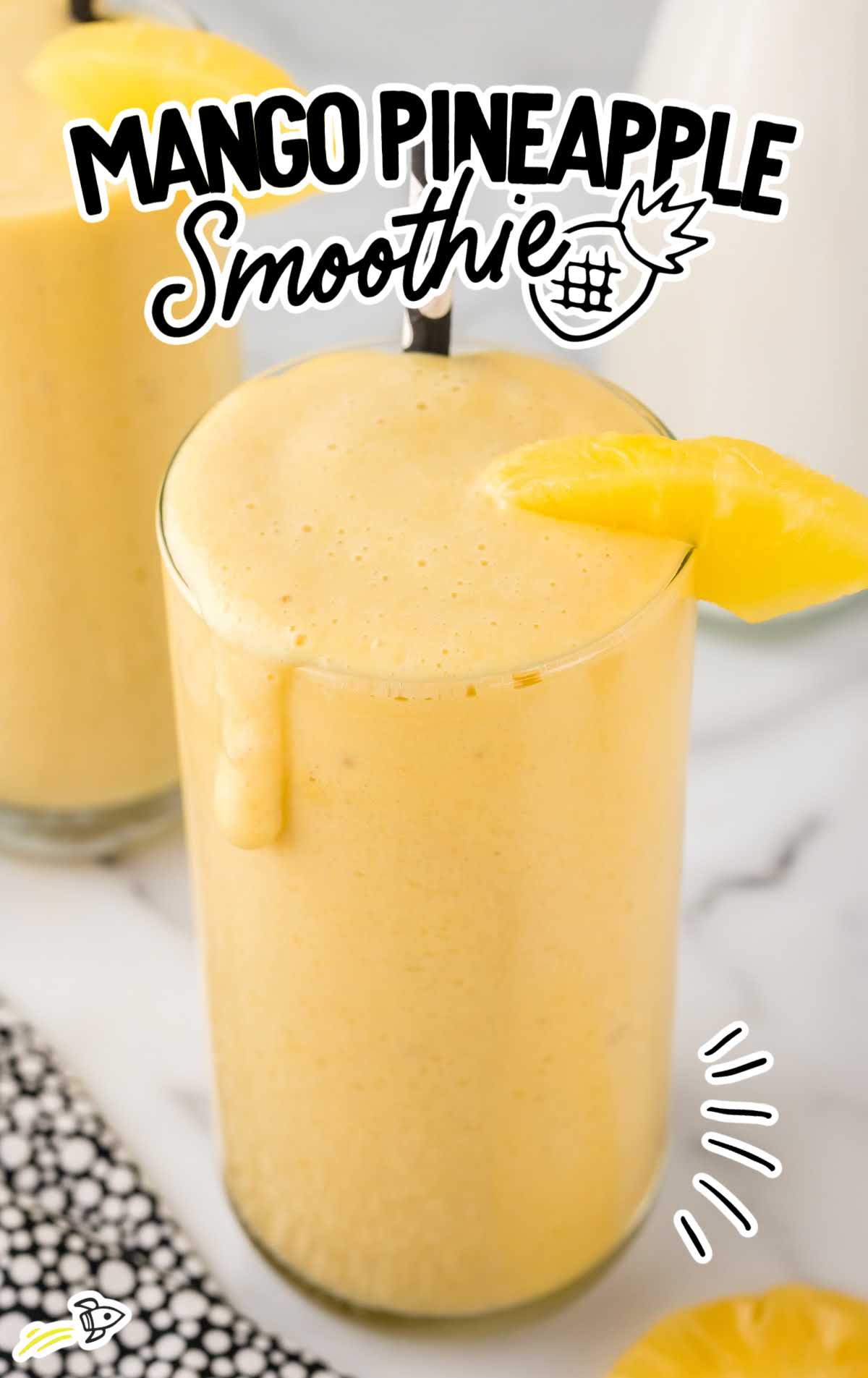 a close up shot of Mango Pineapple Smoothie in a tall glass