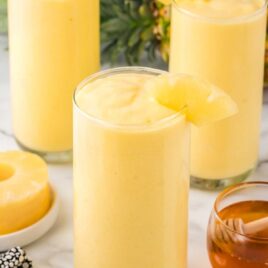 a close up shot of Mango Pineapple Smoothie in a tall glass