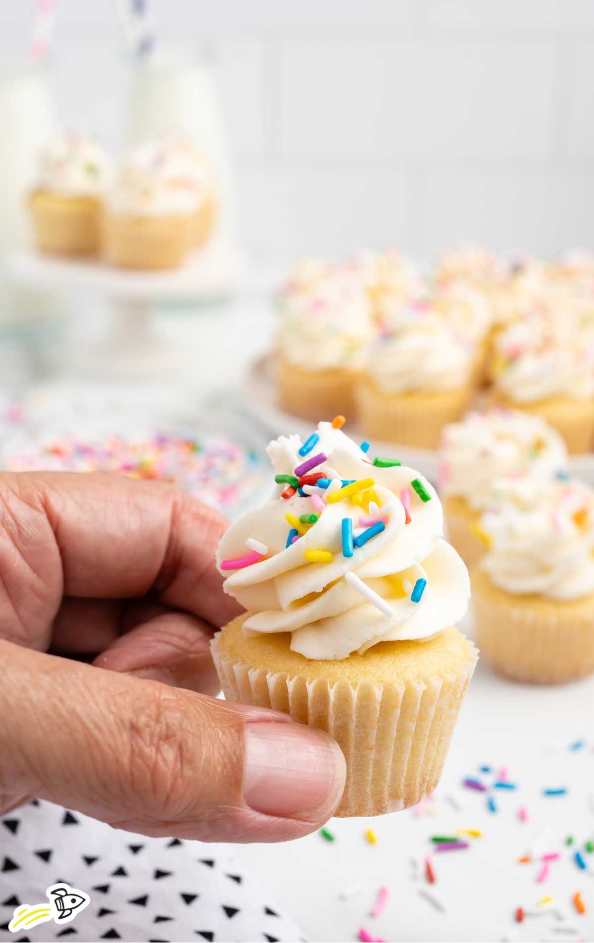 a Mini Cupcakes topped with sprinkles being held