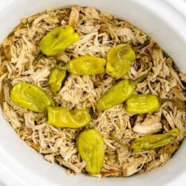 a crockpot of shredded chicken with pepperoncini