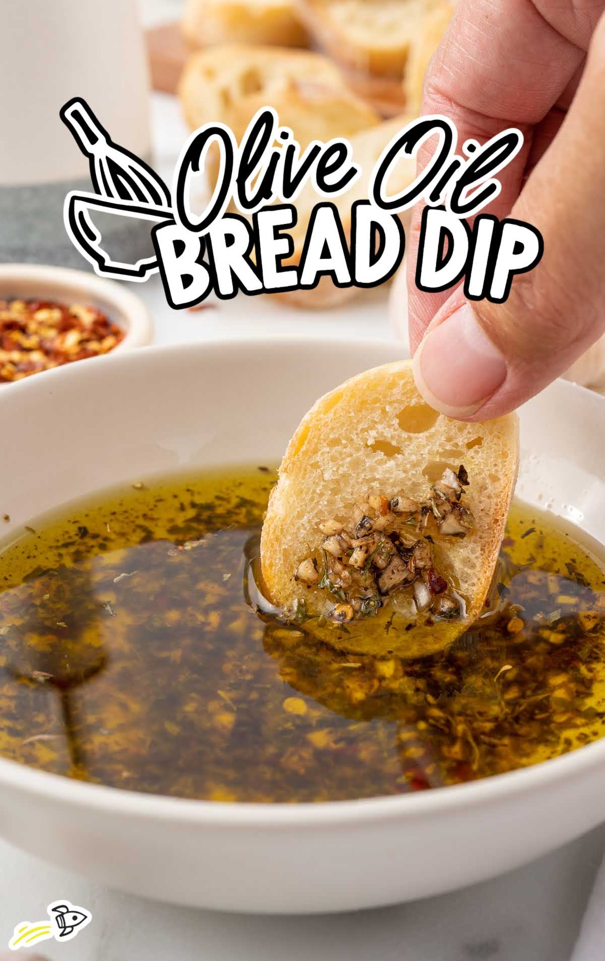 a slice of bread dipped in a bowl of olive oil