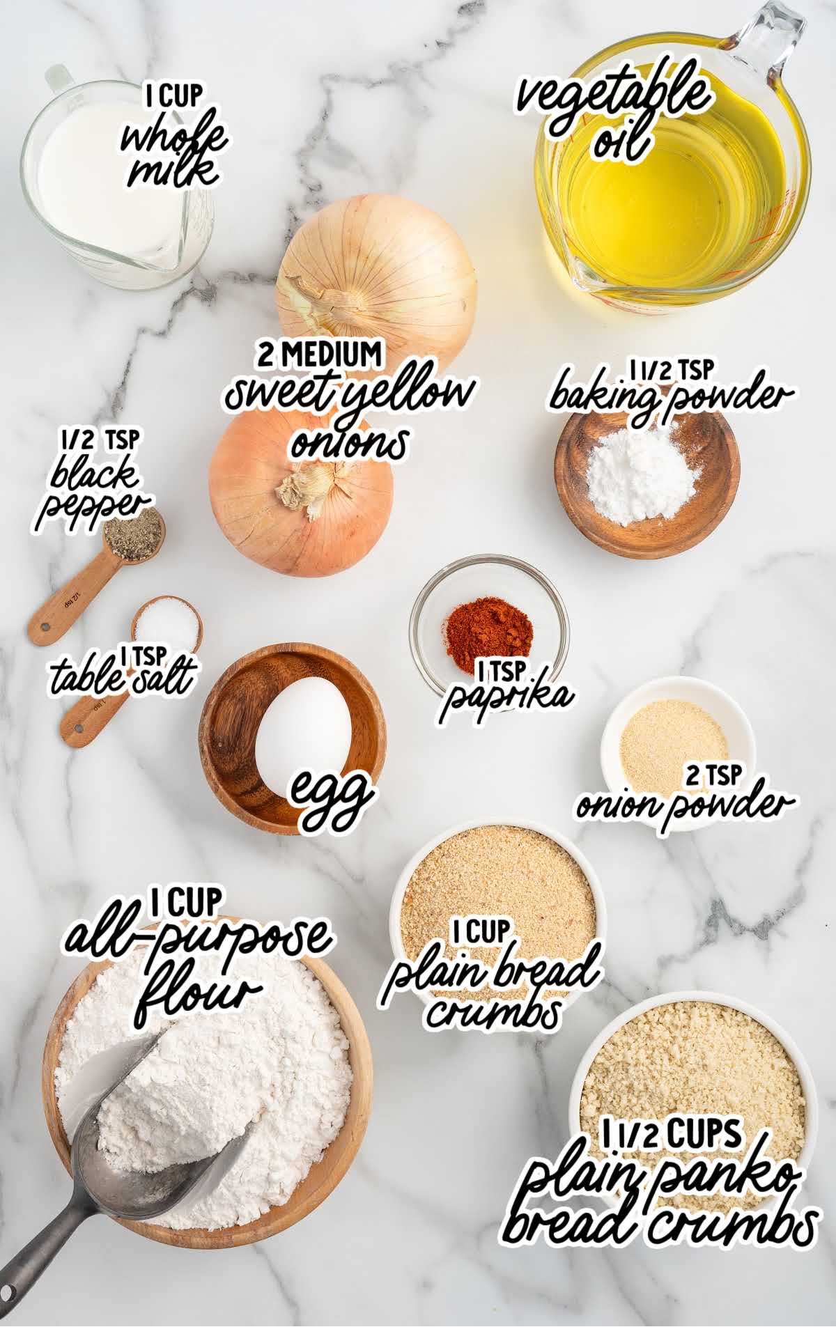 Labeled ingredients for homemade onion rings arranged on a marble surface