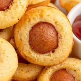 Mini corn dog muffins served with ketchup in a white ramekin.