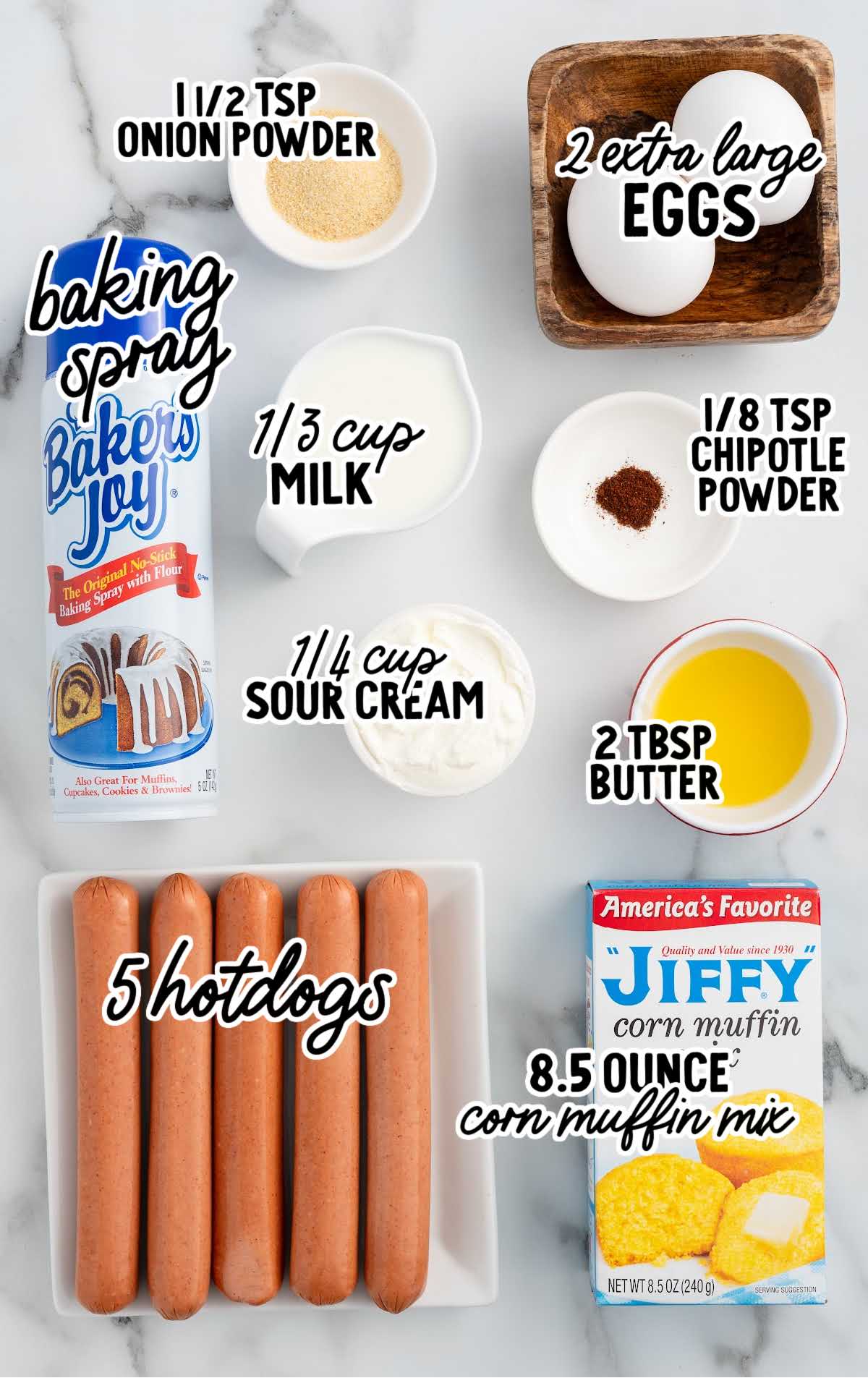 Overhead shot of ingredients for corn dog muffins including Jiffy mix, hot dogs, eggs, and seasonings.