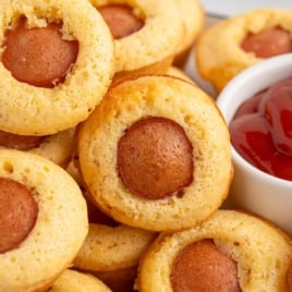 Close-up of corn dog muffins with ketchup, text overlay "Corn Dogs Muffins."