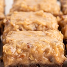 German chocolate brownies topped with coconut pecan frosting, text overlay reading 'Irresistibly Delicious'.