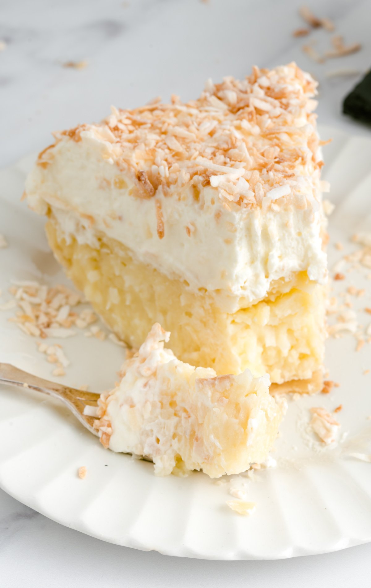 a slice of Coconut Cream Pie on a plate with a fork