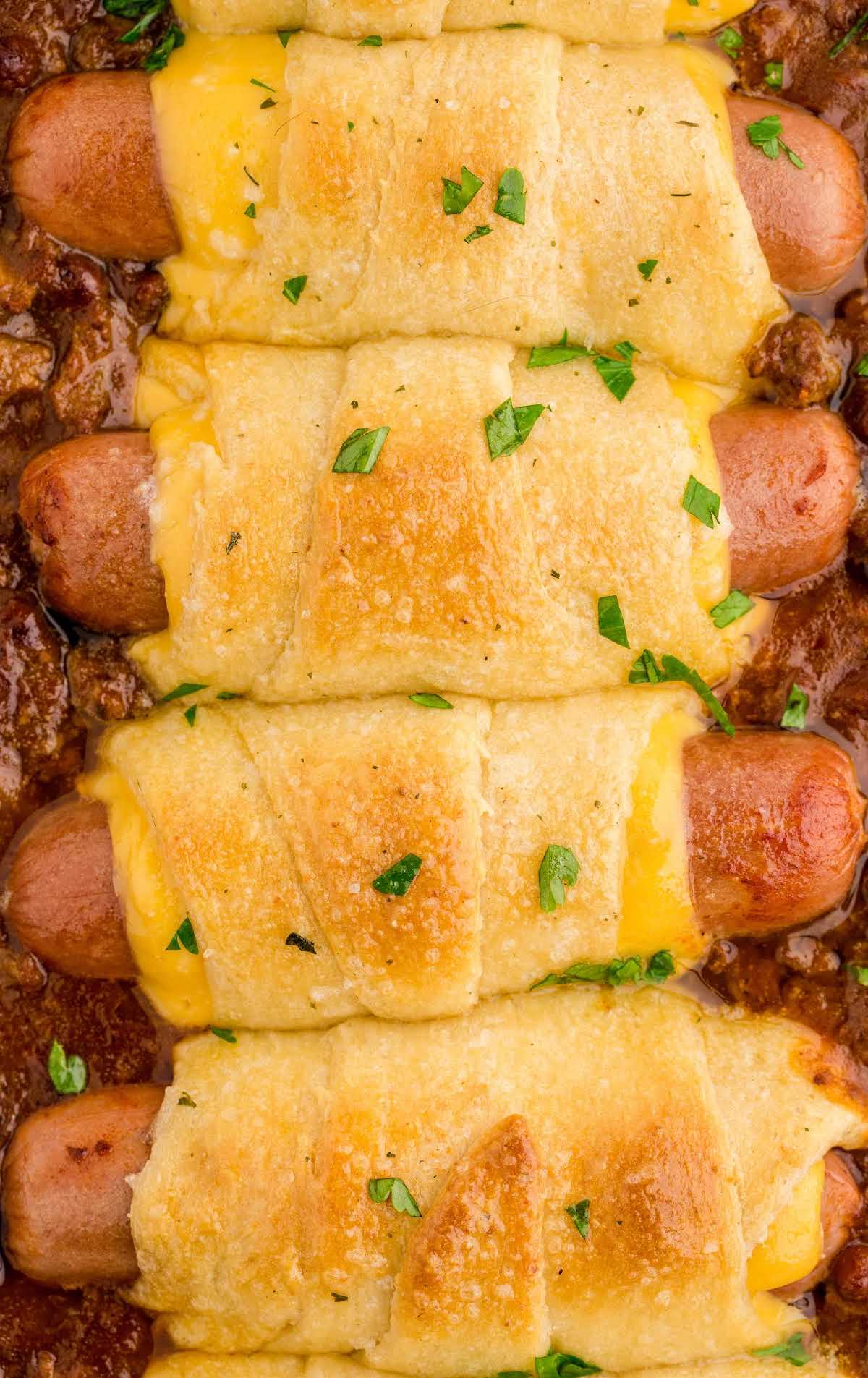 close up overhead shot of a baking dish of chili cheese dog bake garnished with parsley