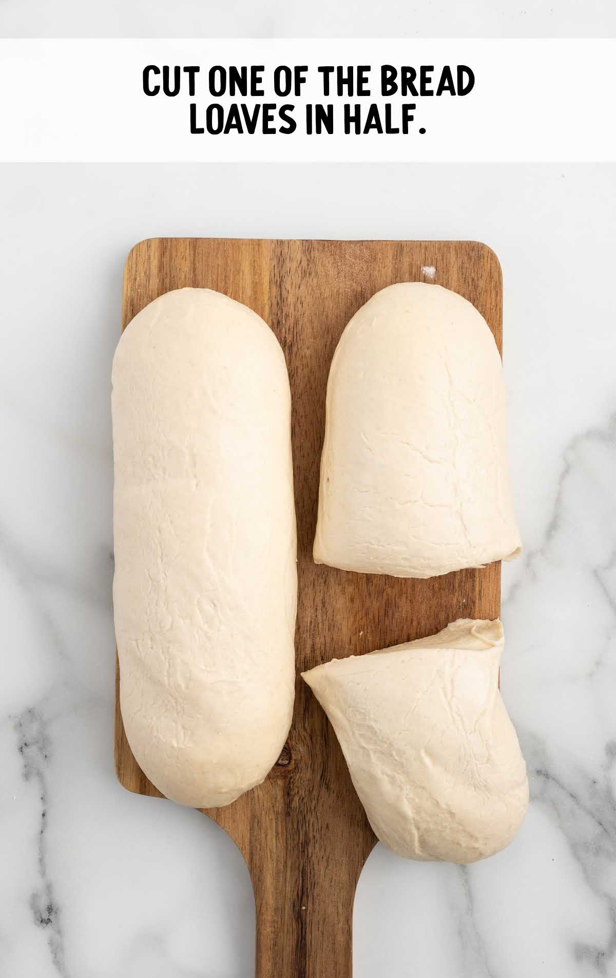 bread loaves cut in half on a wooden board