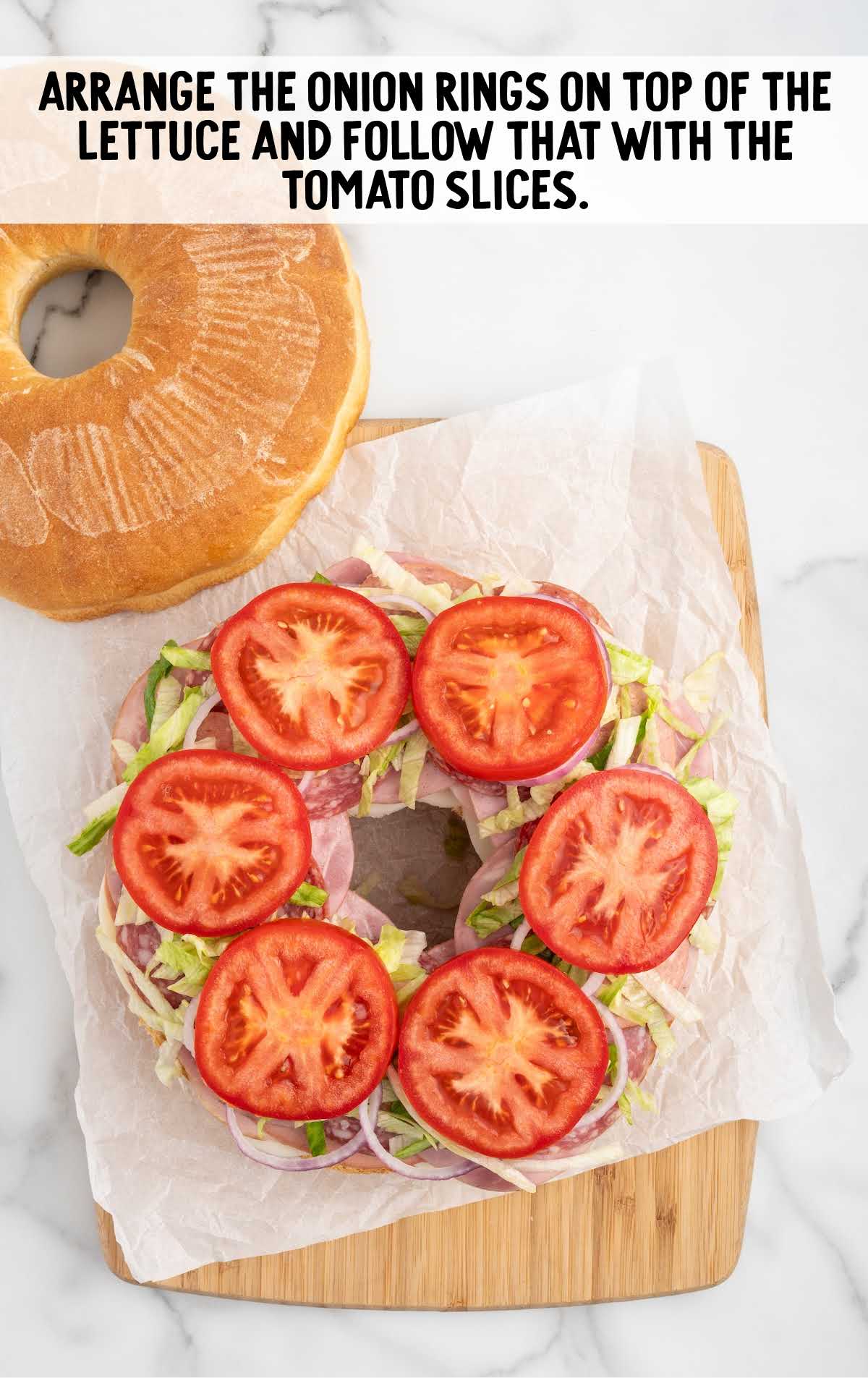 onion rings placed on top of the lettuce then topped with tomato slices