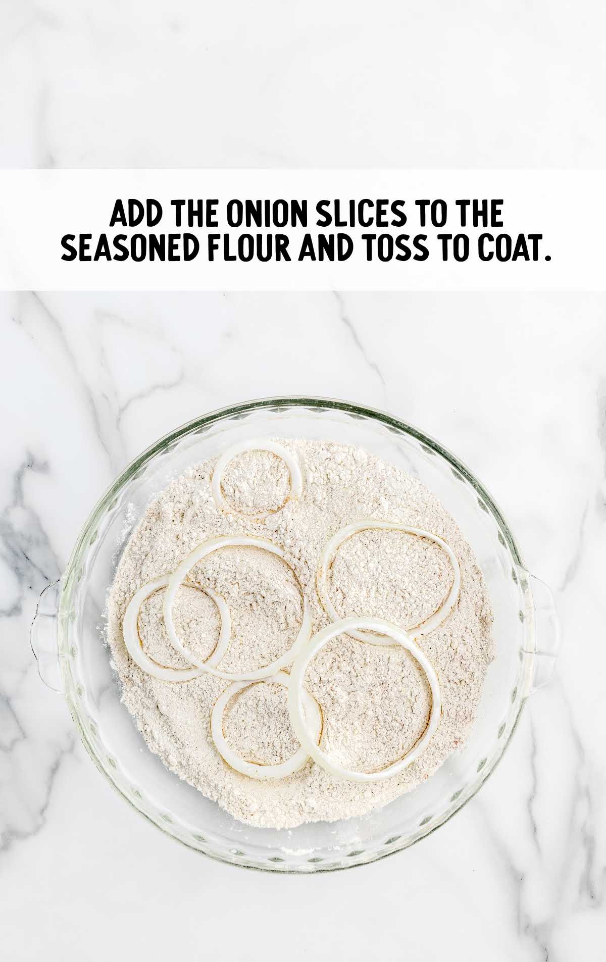 onion slices coated in a bowl of seasoned flour