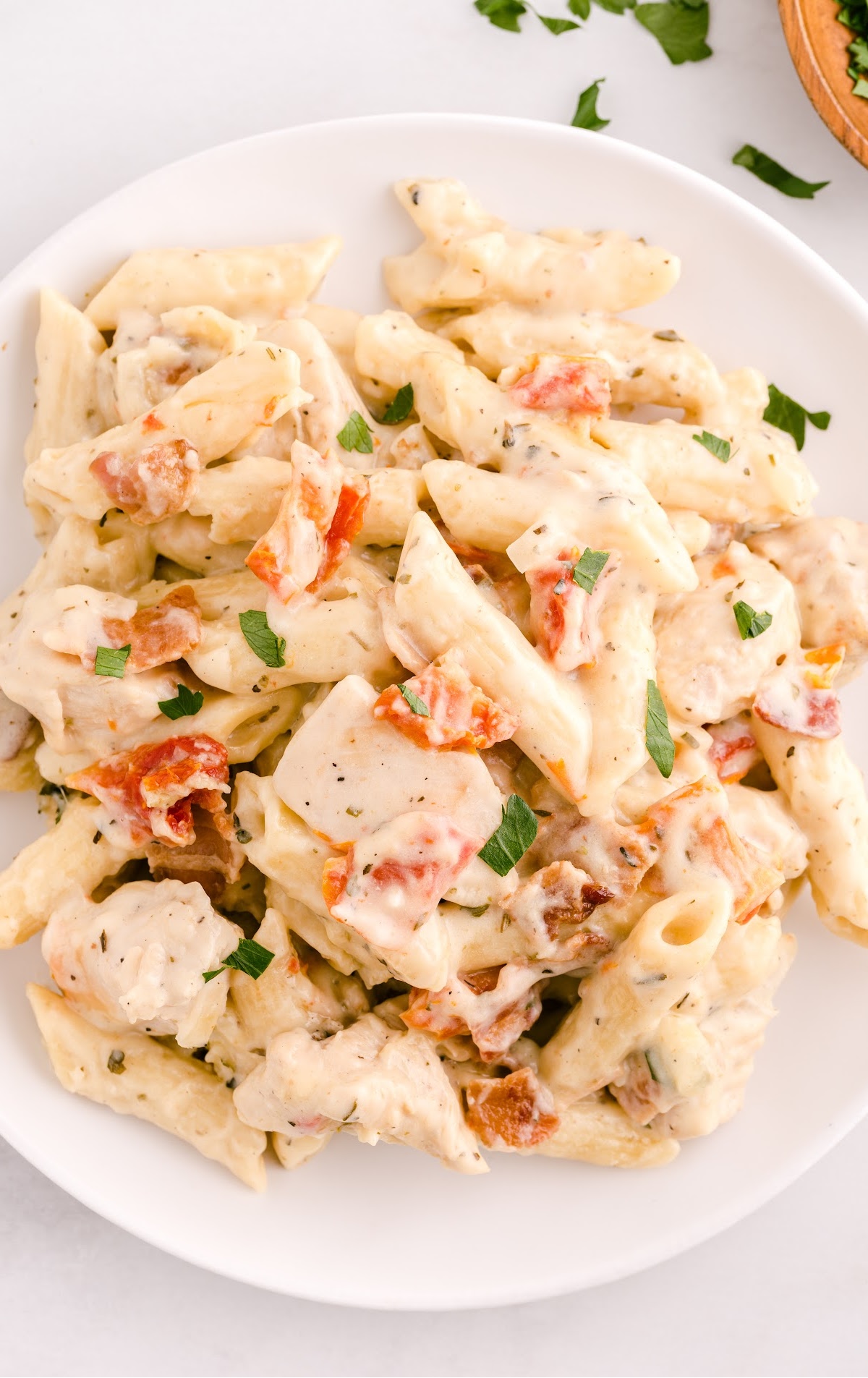 A large white dinner plate full of a serving of chicken bacon ranch pasta casserole.