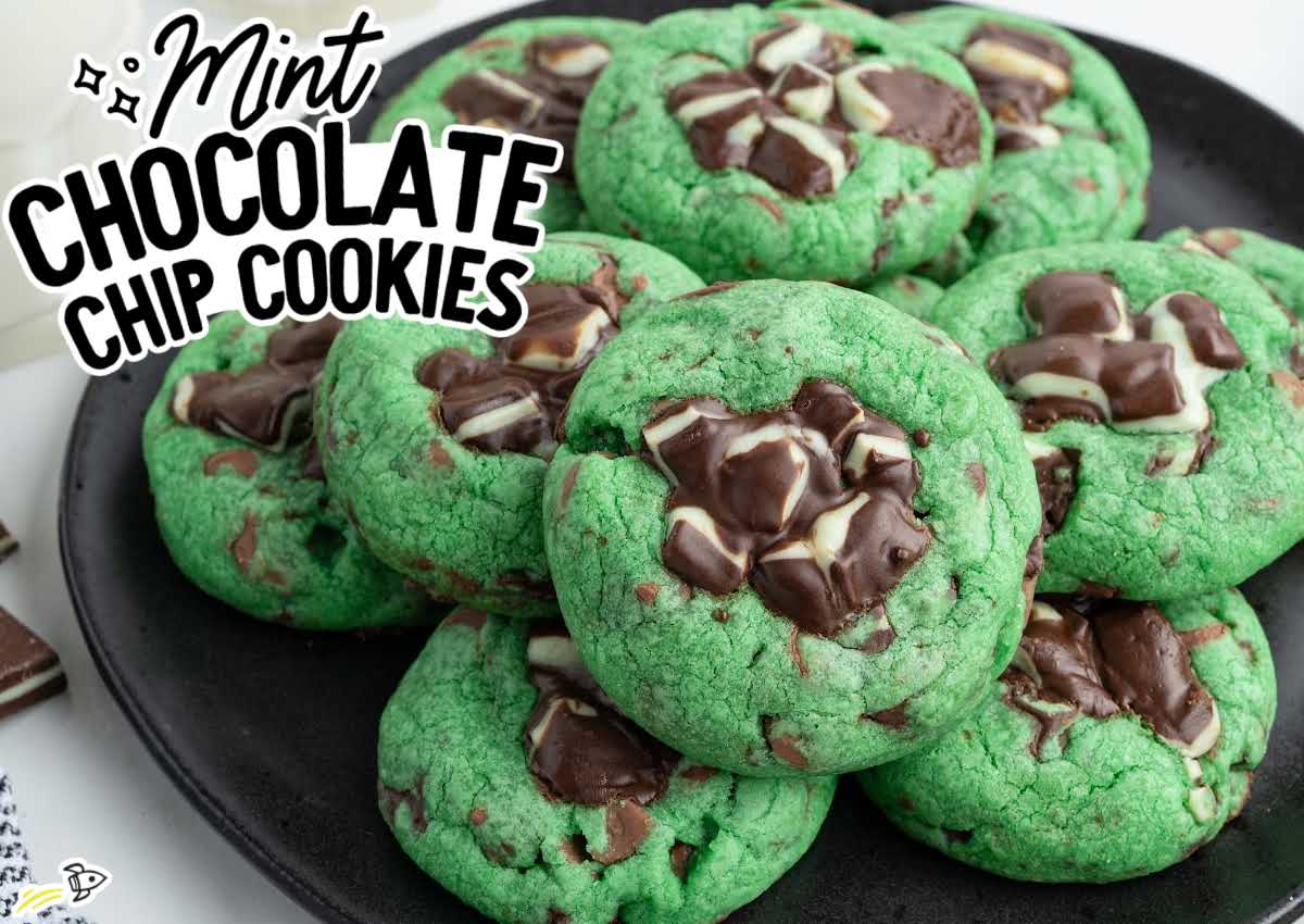 Mint chocolate chip cookies piled on a plate with chopped Andes mints pressed into the tops