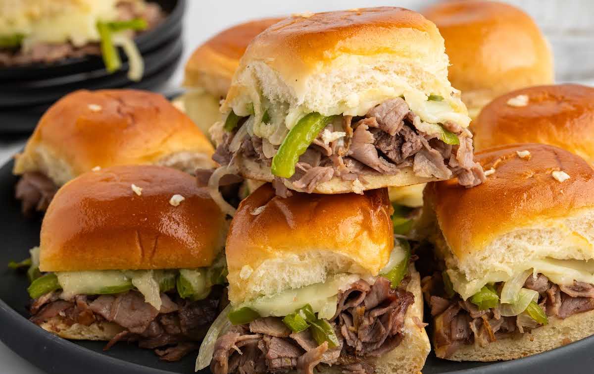 Philly cheesesteak sliders baked together on Hawaiian rolls with gooey melted cheese
