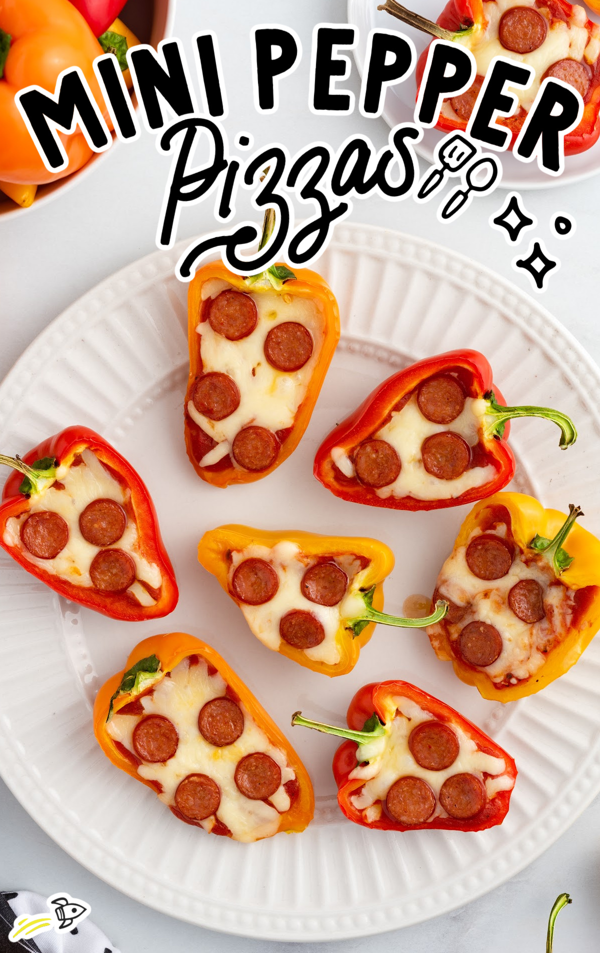 A white dinner plate with seven mini pepper pizzas on it. 