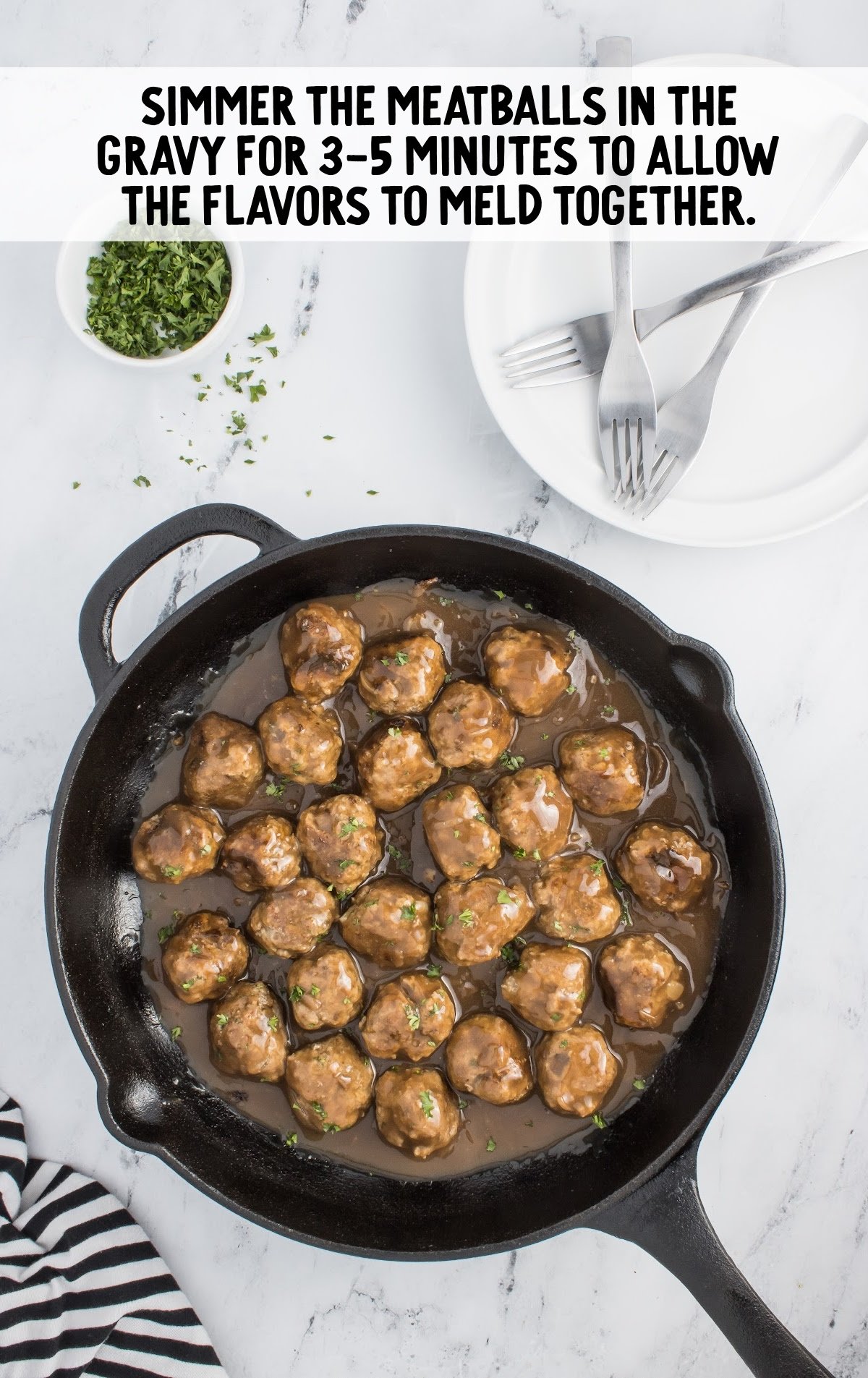 a skillet of prepared gravy and meatballs.