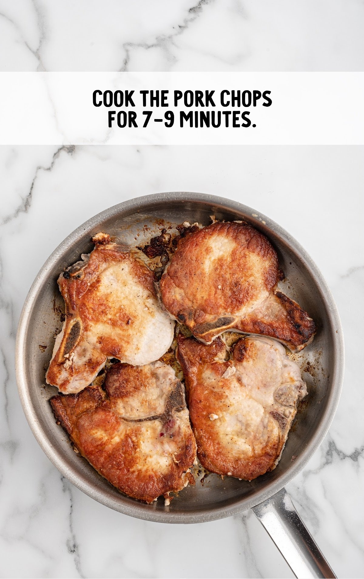 seasoned pork chops cooking in a pan