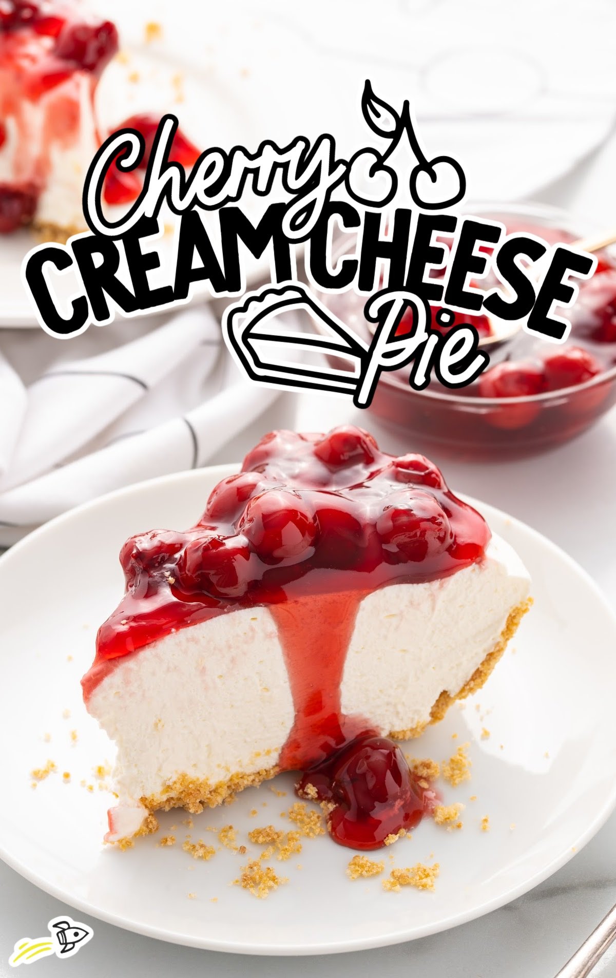 slice of cherry cream cheese pie on a plate with cherry pie filling spilling over the side