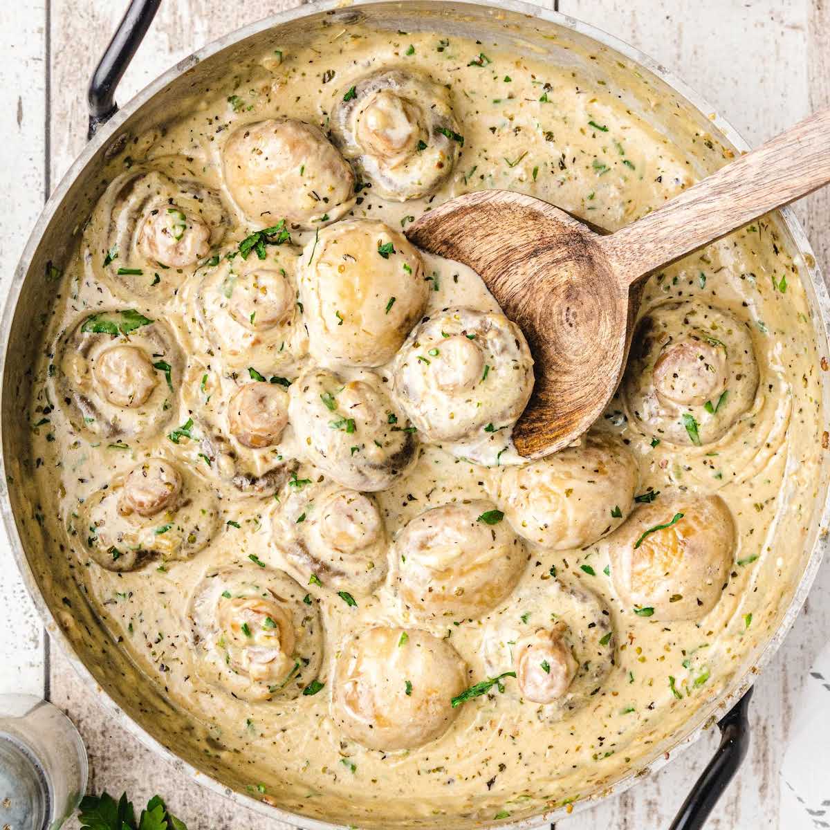 Close-up image of creamy garlic parmesan mushrooms, plated and garnished, designed for a printable recipe card.