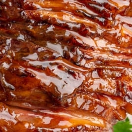 Close-up of glazed spiral ham with text overlay reading “The Yummiest Ever Honey Baked Ham Recipe.”