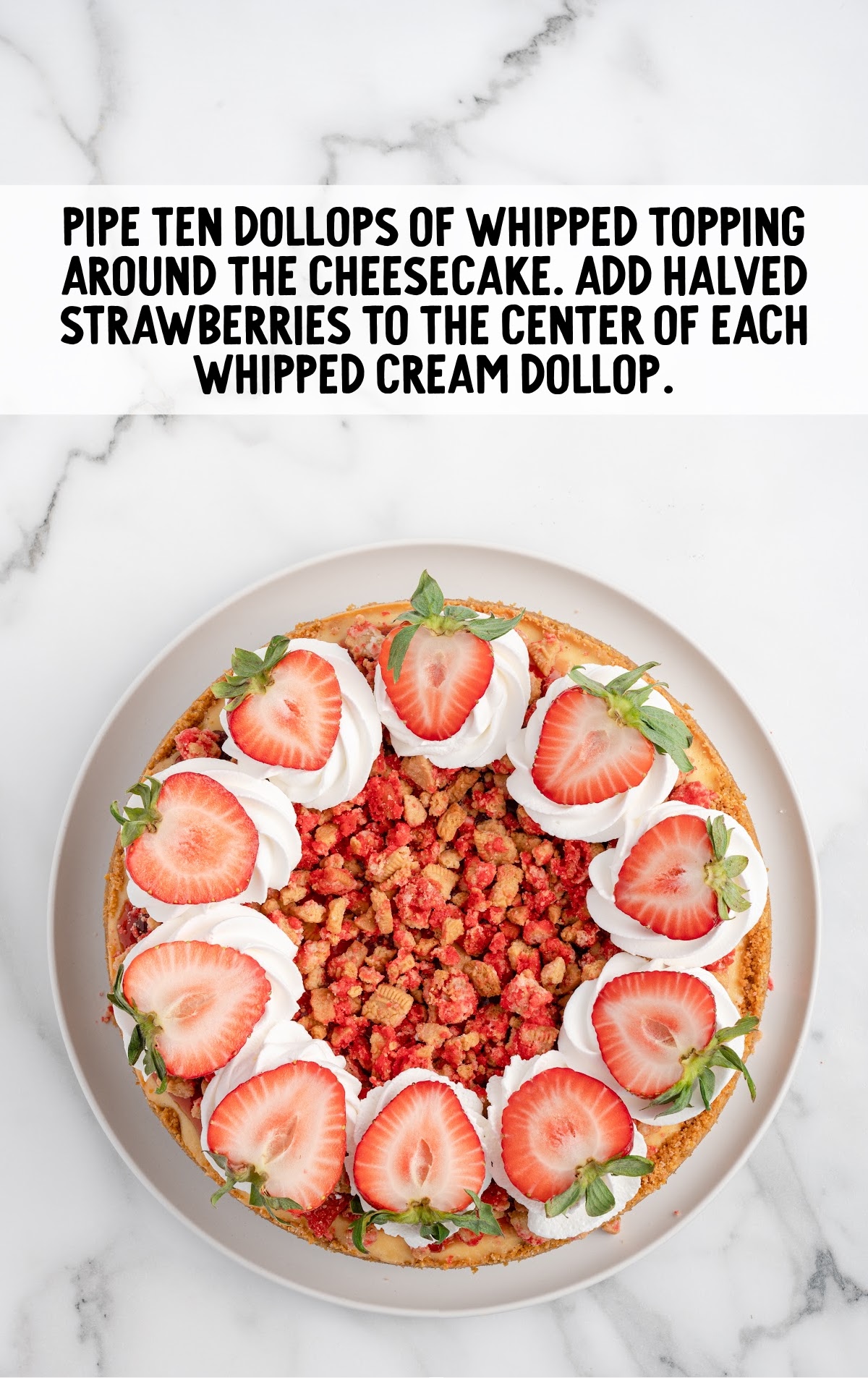 strawberry crunch cheesecake topped with whipped cream and fresh sliced strawberries 