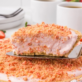 Slice of strawberry crunch freezer pie with crispy topping and creamy filling.