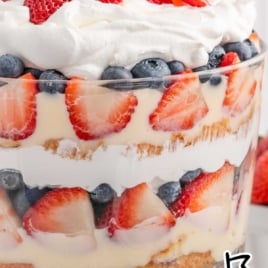 a jar of 4th of July Trifle topped with diced strawberries and blueberries