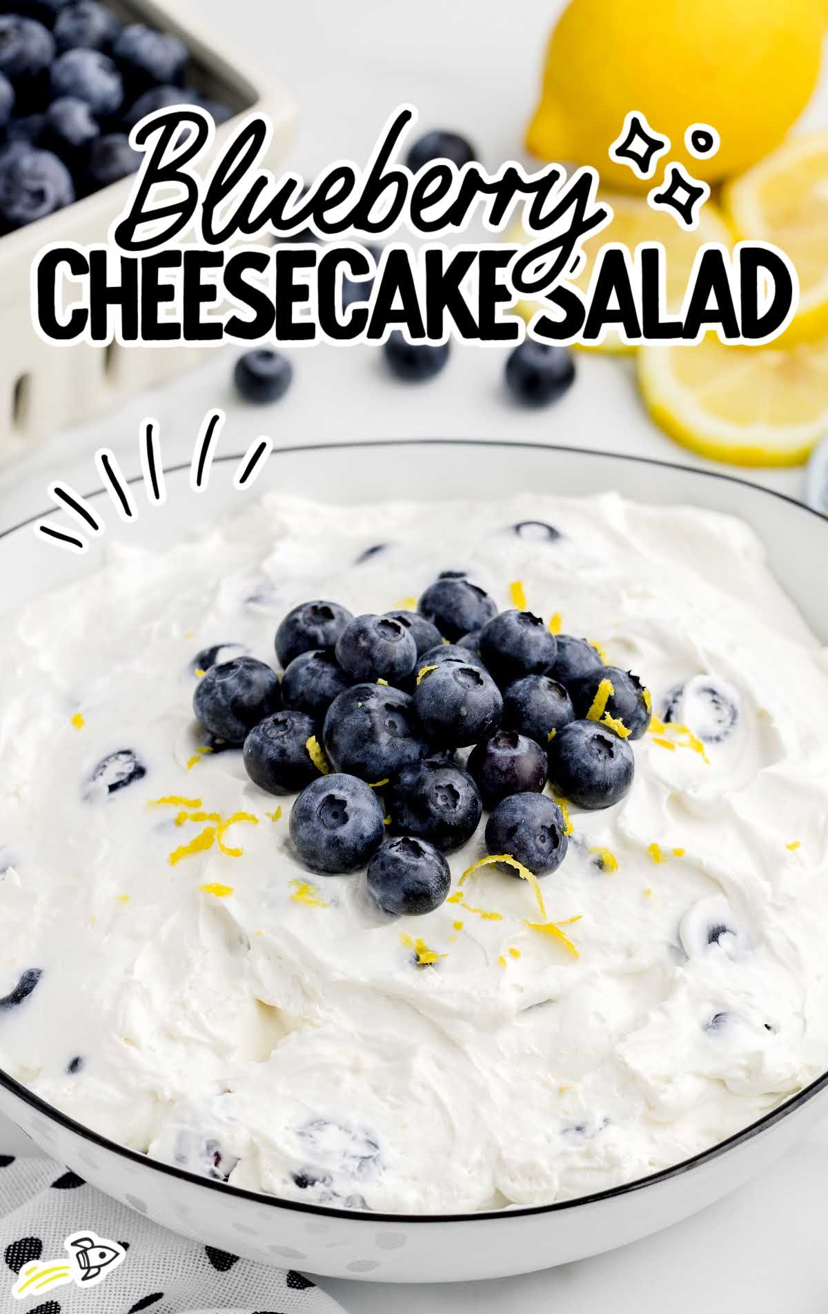 a bowl of Blueberry Cheesecake Salad topped with blueberries and lemon zest