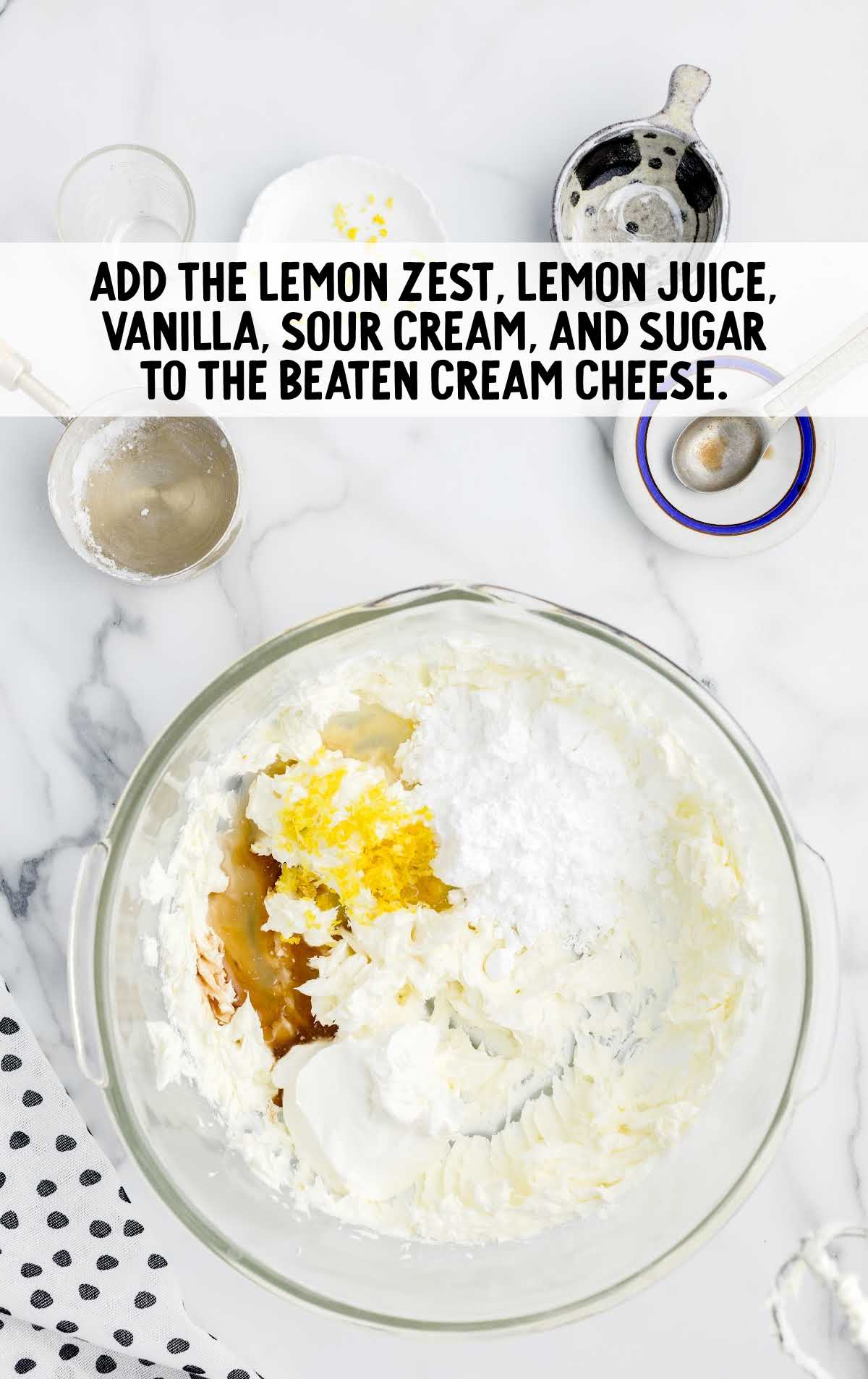 lemon zest, lemon juice, vanilla extract, sour cream, and powdered sugar added to the beaten cream cheese in a bowl