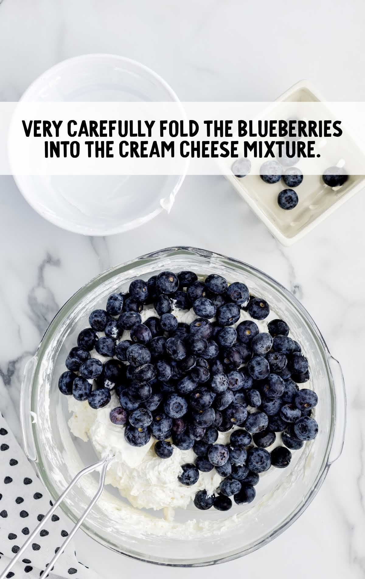 blueberries folded into the cream cheese mixture in a bowl