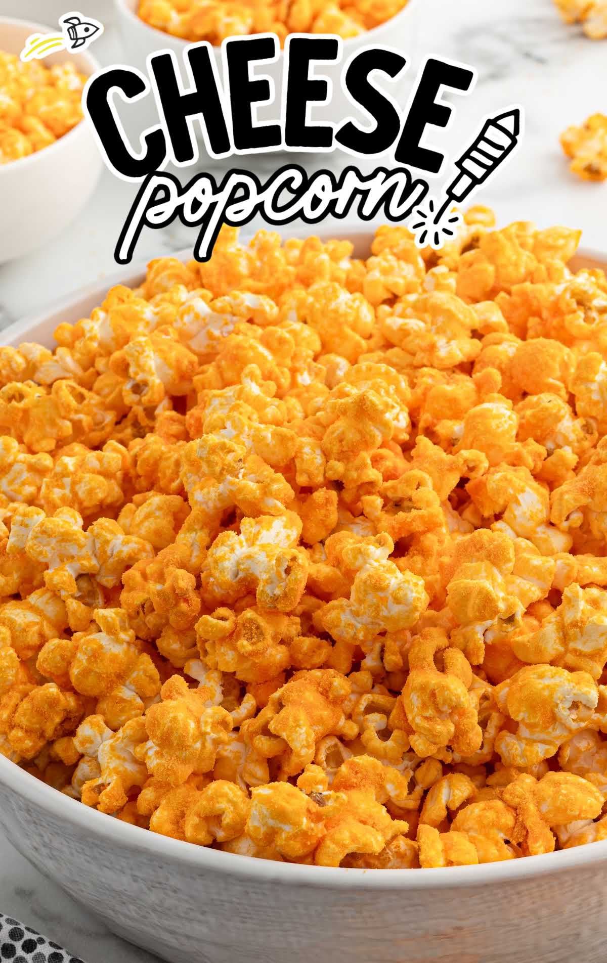 A bowl of cheesy popcorn with a bold title overlay reading "Cheese Popcorn" in a fun, playful font.