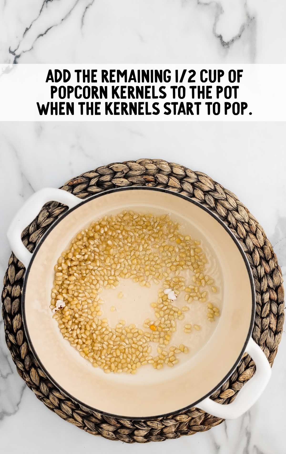 popcorn kernels added to the pot of oil
