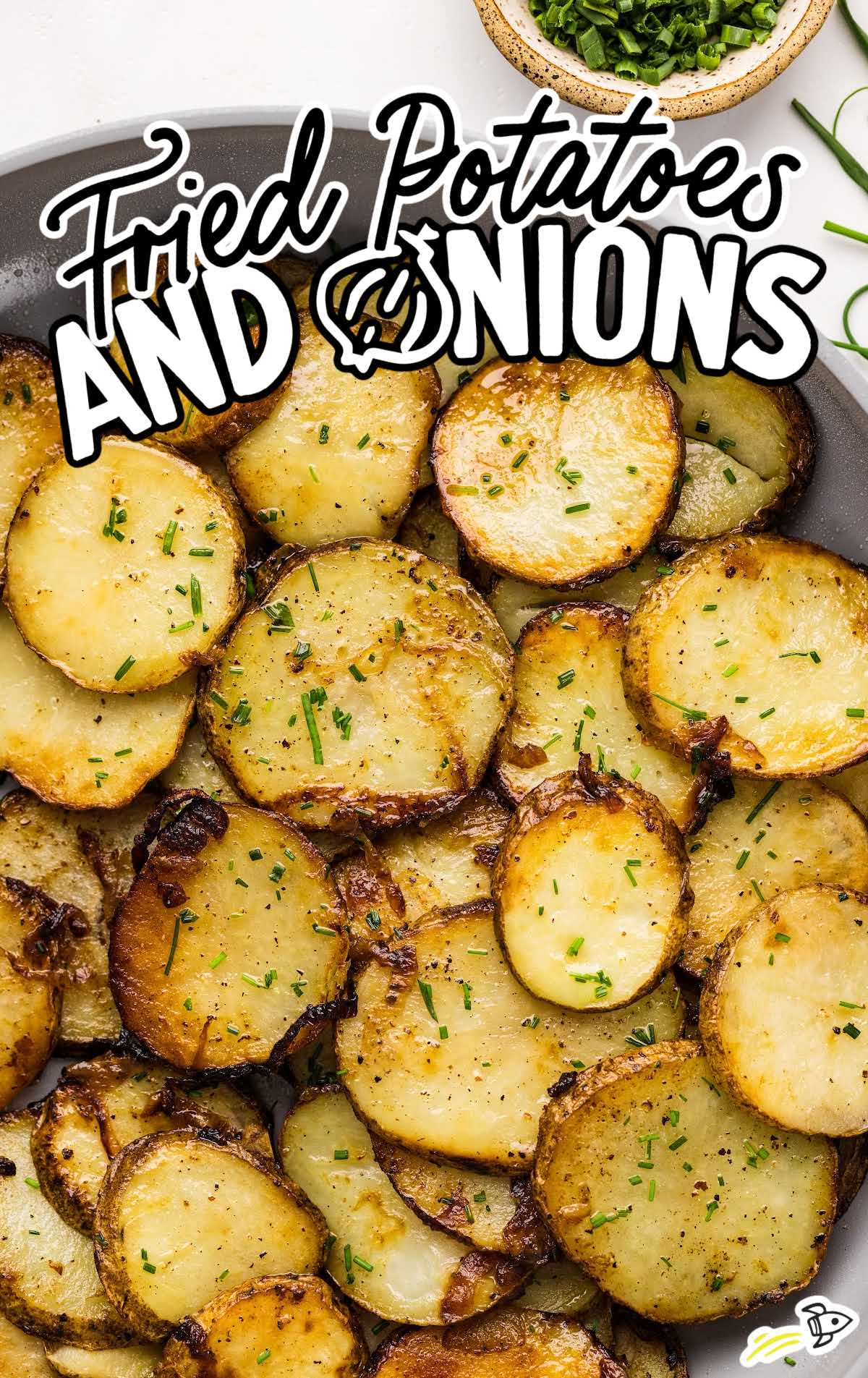 fried potatoes topped with chives in a skillet