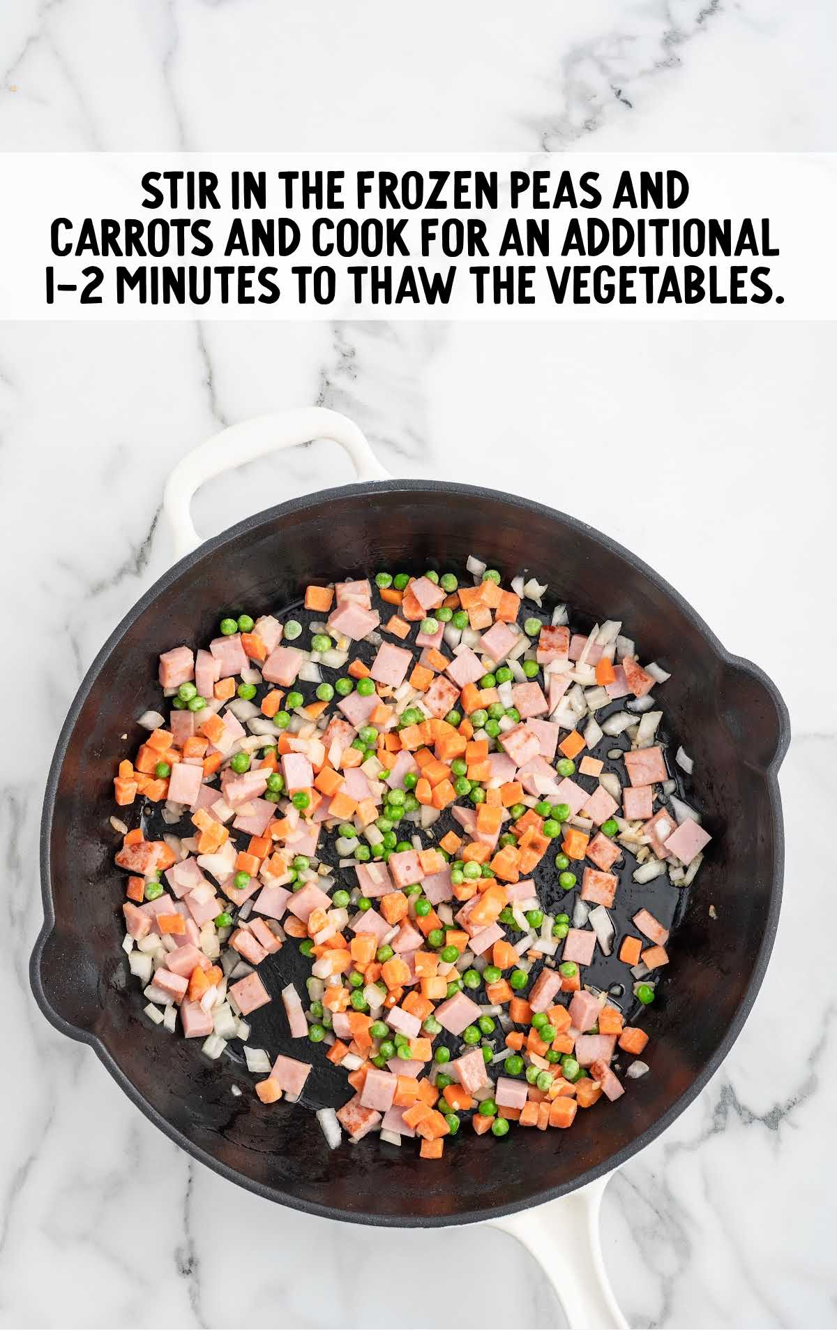 frozen peas and carrots added to the skillet of ham