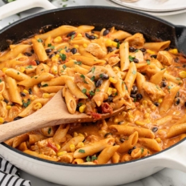 a skillet of chicken pasta garnished with parsley
