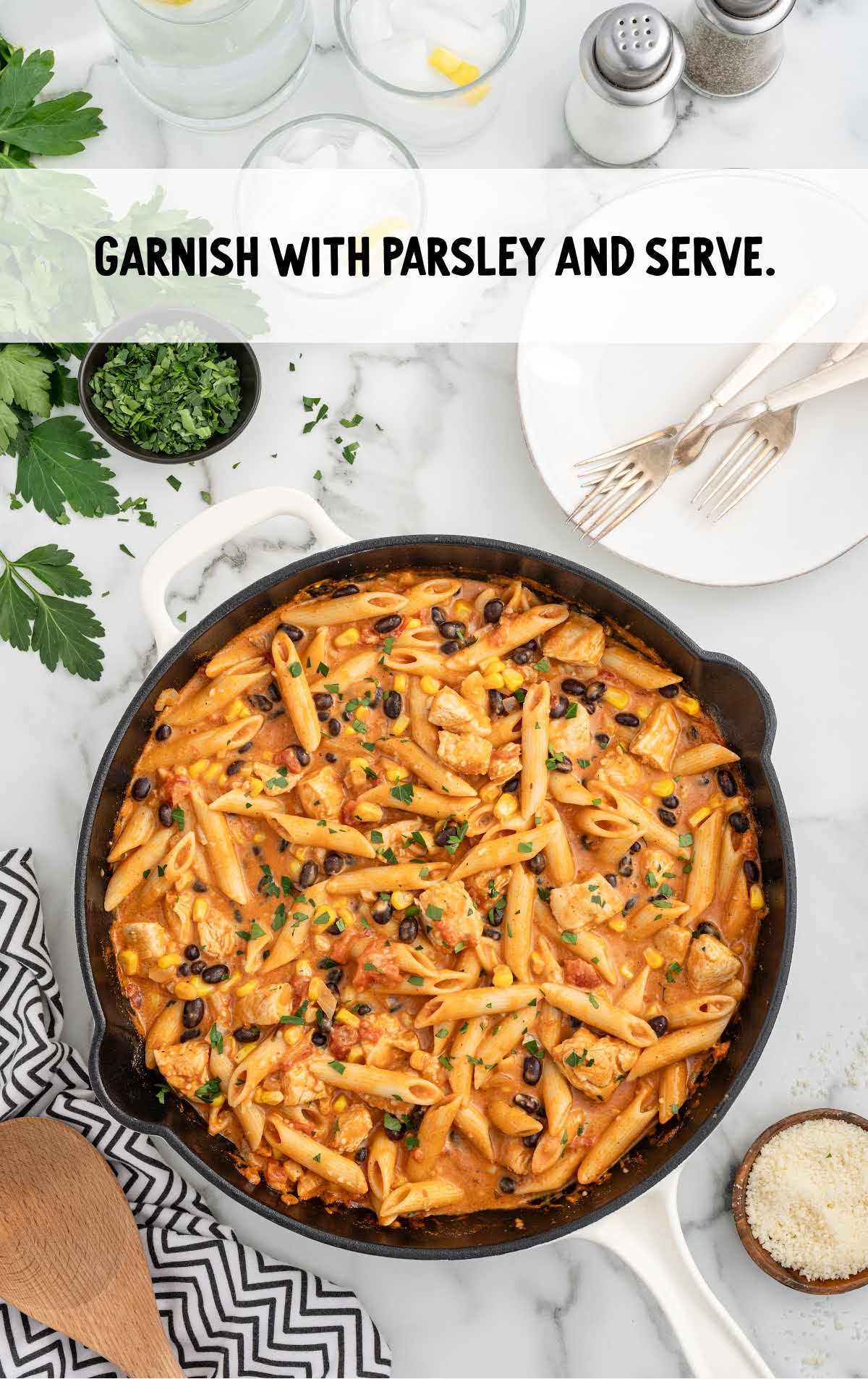a skillet of chicken pasta garnished with parsley