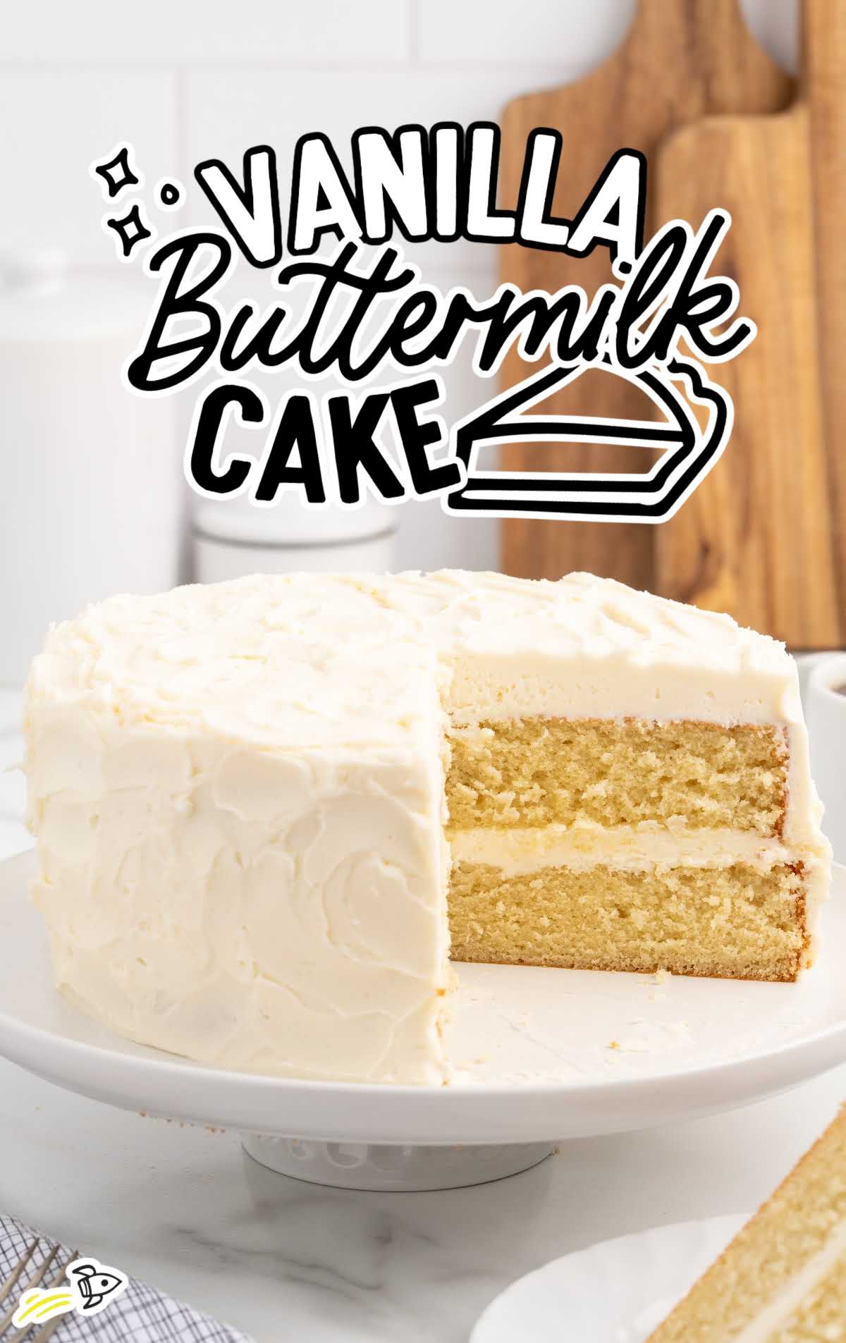 Vanilla Buttermilk Cake with a slice missing on a cake stand
