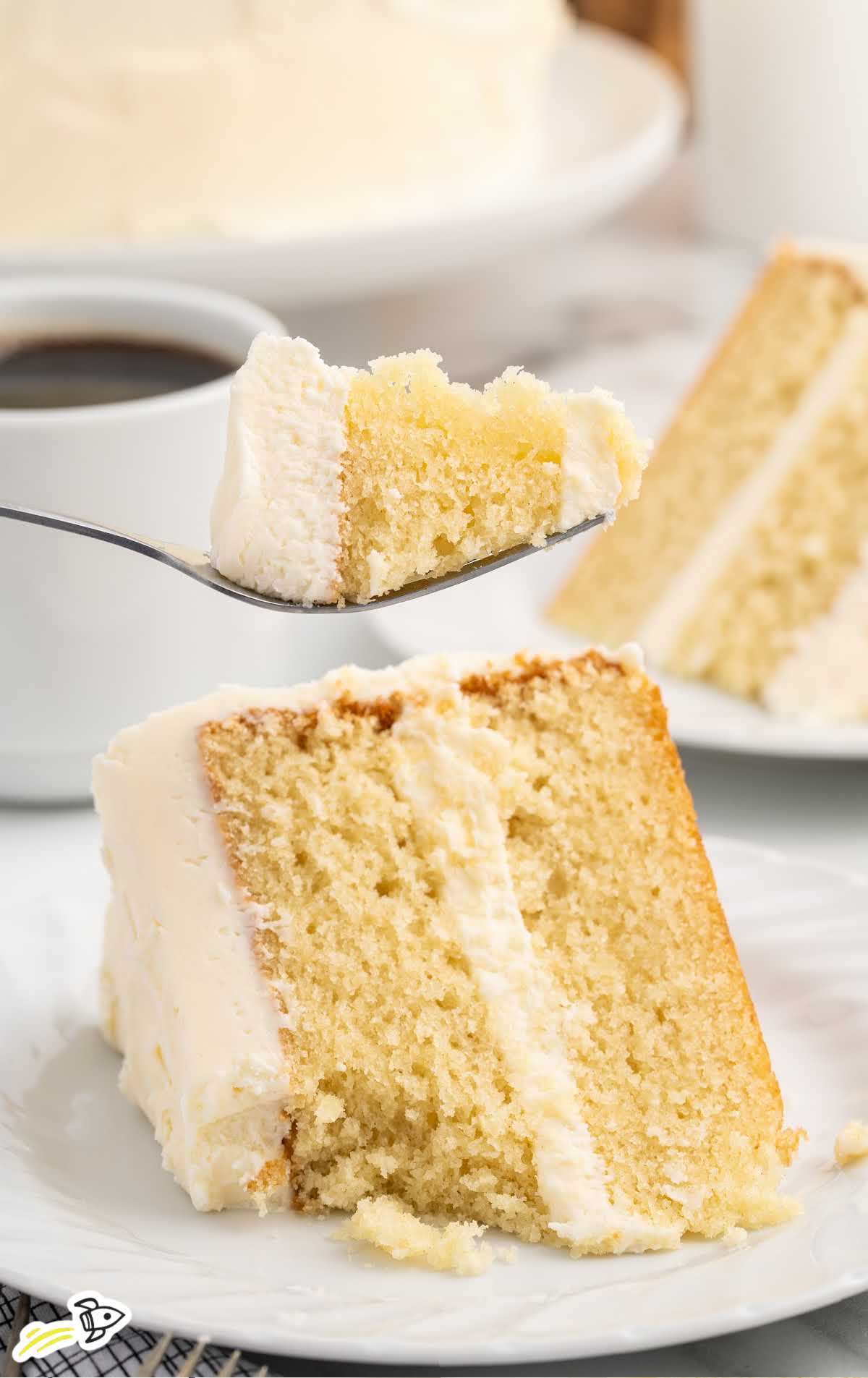 a slice of Vanilla Buttermilk Cake on a plate with a fork