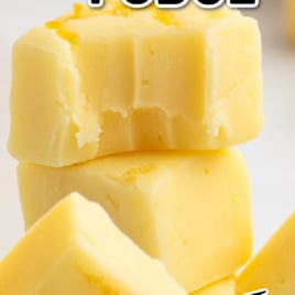 A stack of creamy yellow lemon fudge pieces, some with visible zest, topped with a text overlay that reads โLemon Fudge Recipeโ and โVintage Recipe!โ.
