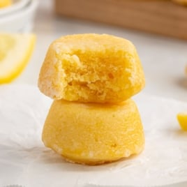 two lemon drop cakes stacked on top of each other with a bite taken out of the top mini cake
