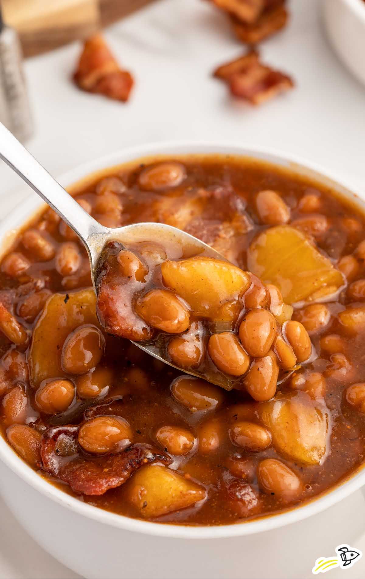 a bowl of Apple Pie Baked Beans with a spoon