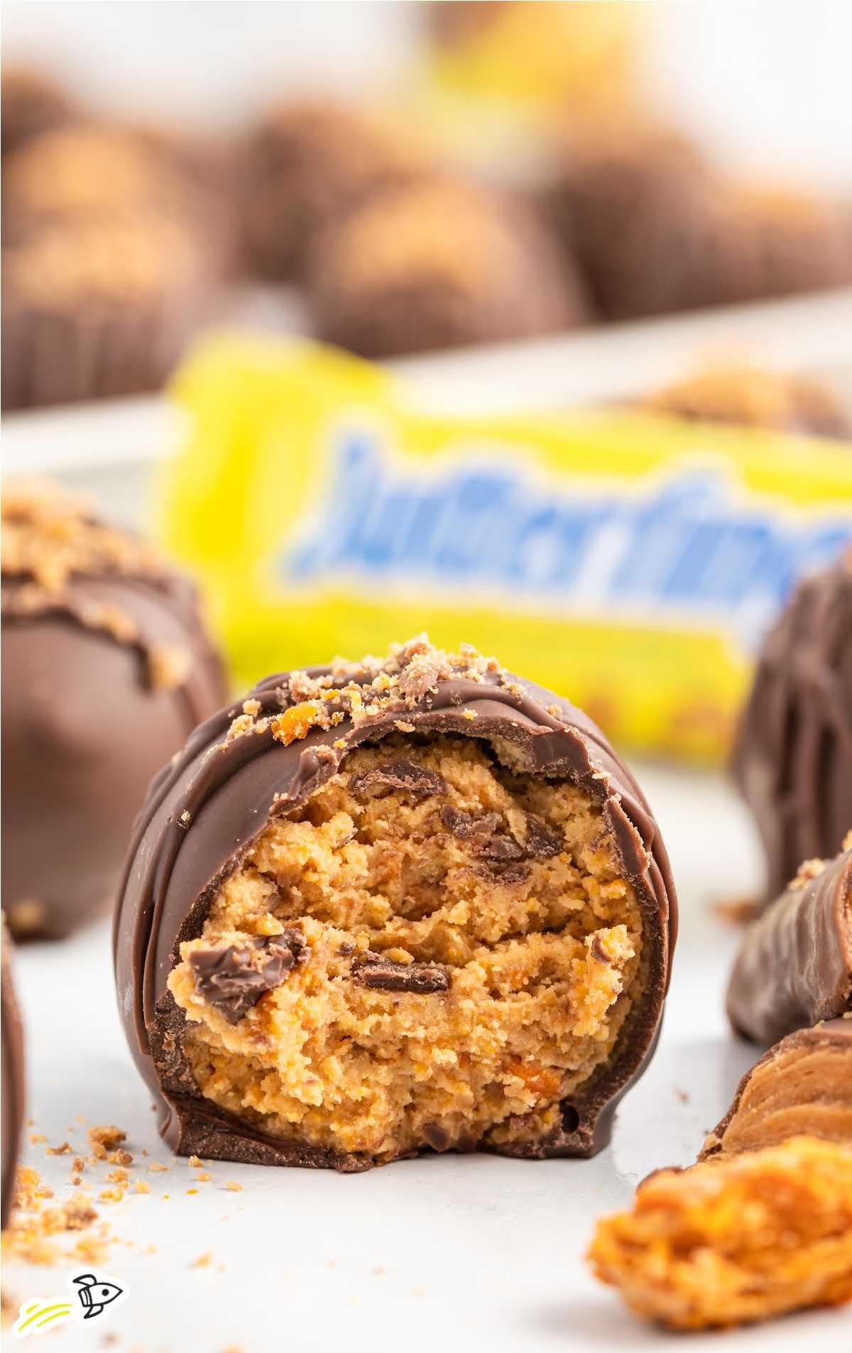 a close up shot of a Butterfinger Ball with a bite taken out of it