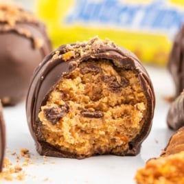 a close up shot of a Butterfinger Ball with a bite taken out of it