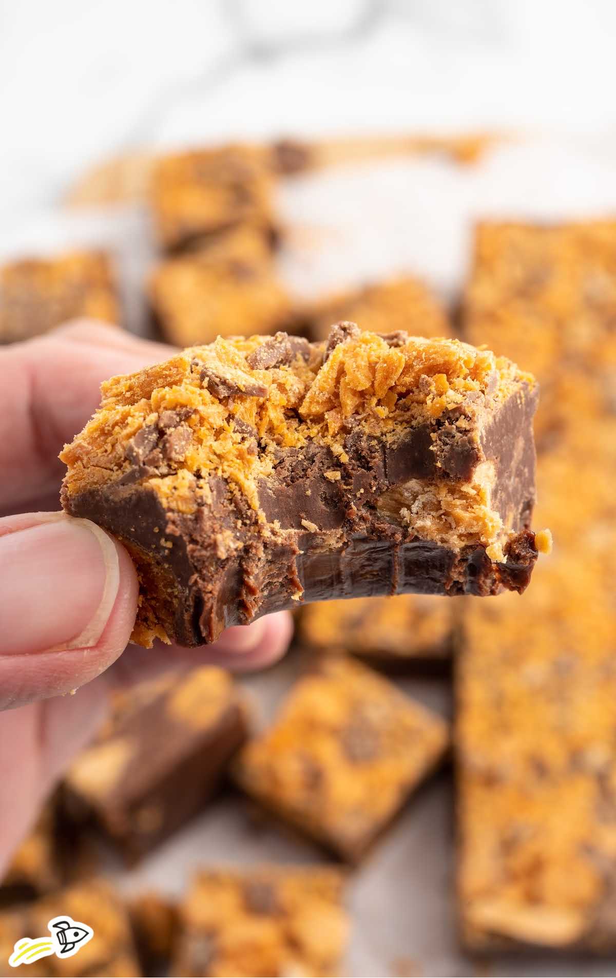a Butterfinger Fudge being held with a bite taken out of it