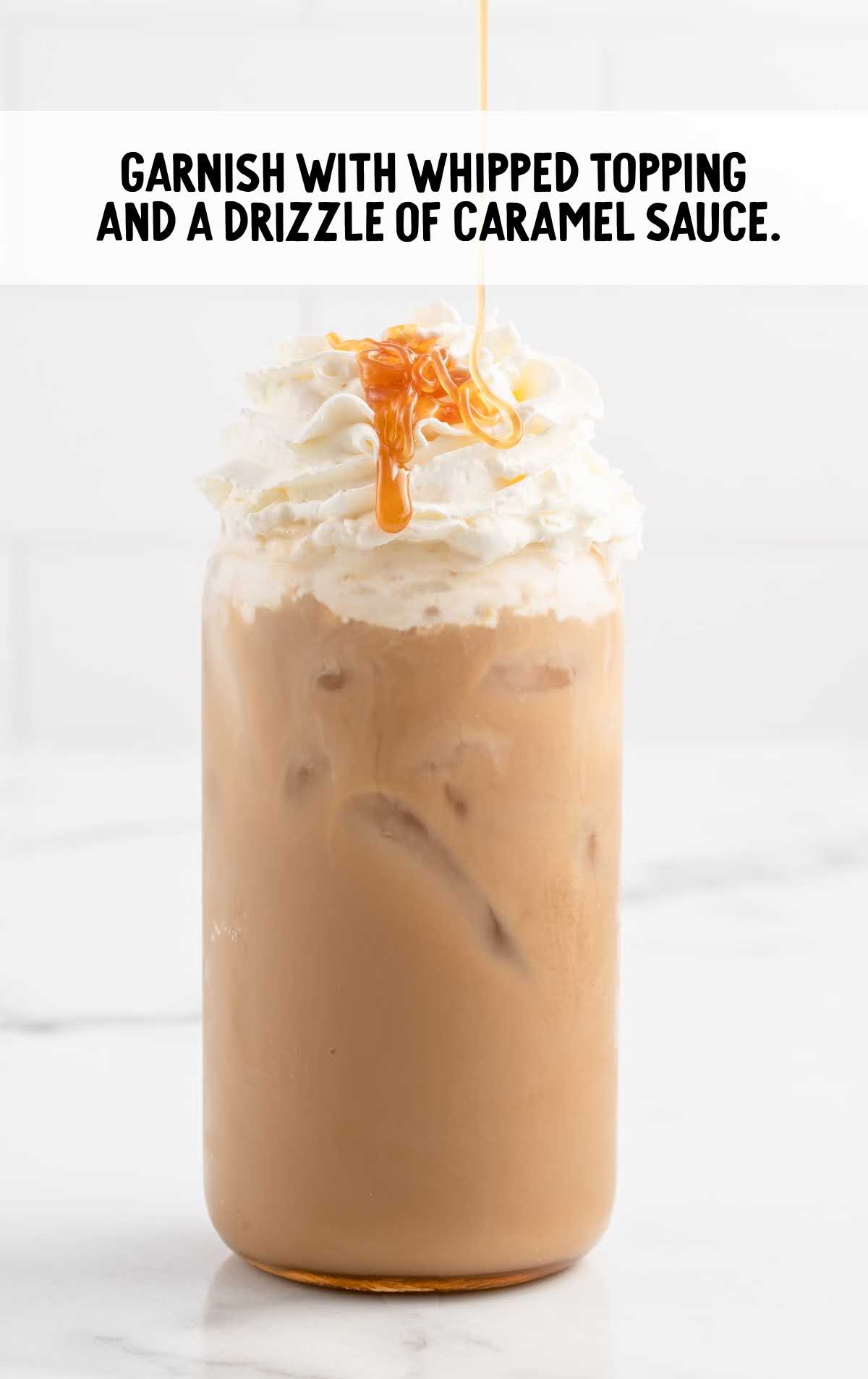 a cup of Caramel Iced Coffee topped with whipped topping and drizzled with caramel sauce