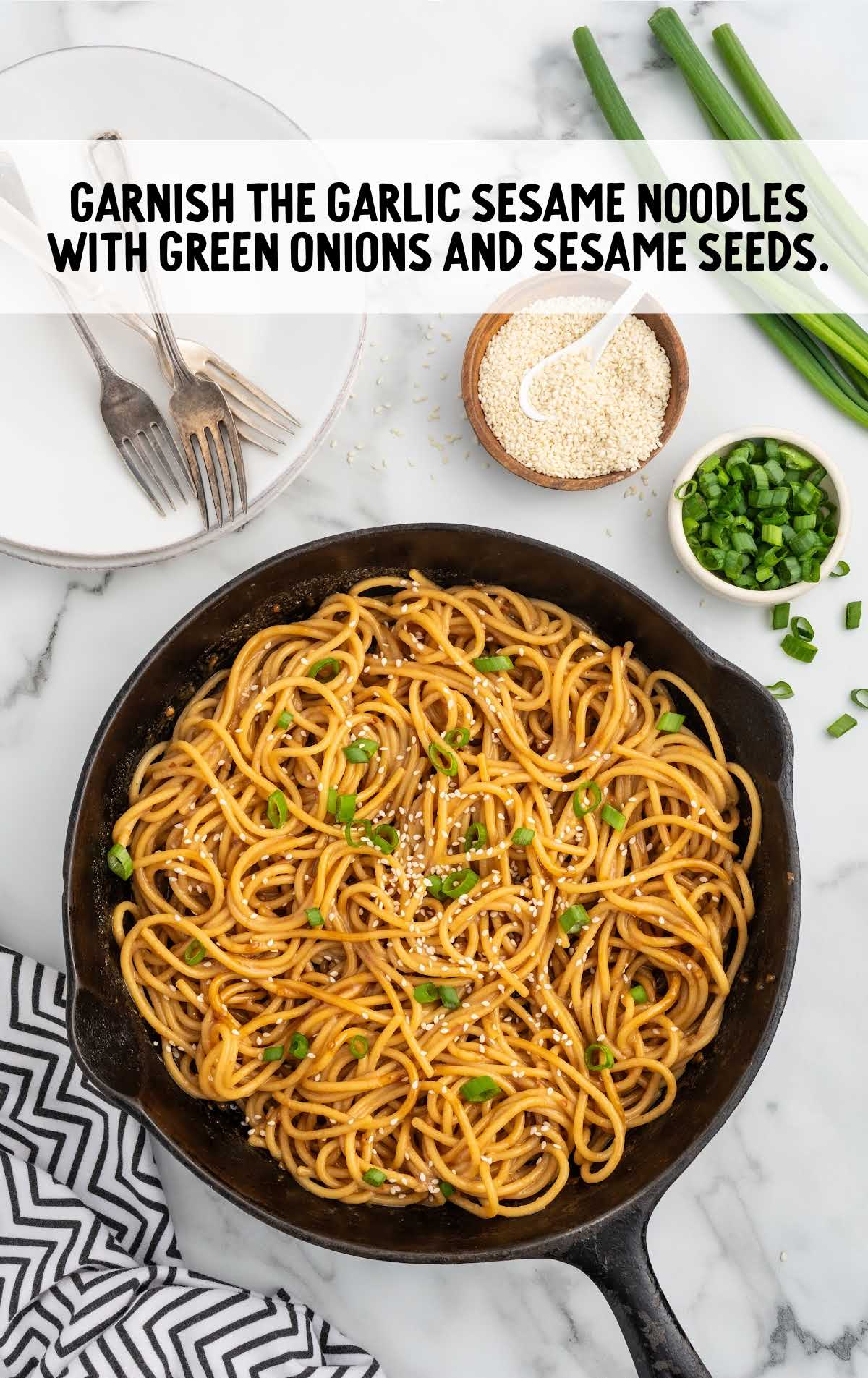 galric sesame noodles garnished with green onions and sesame seeds