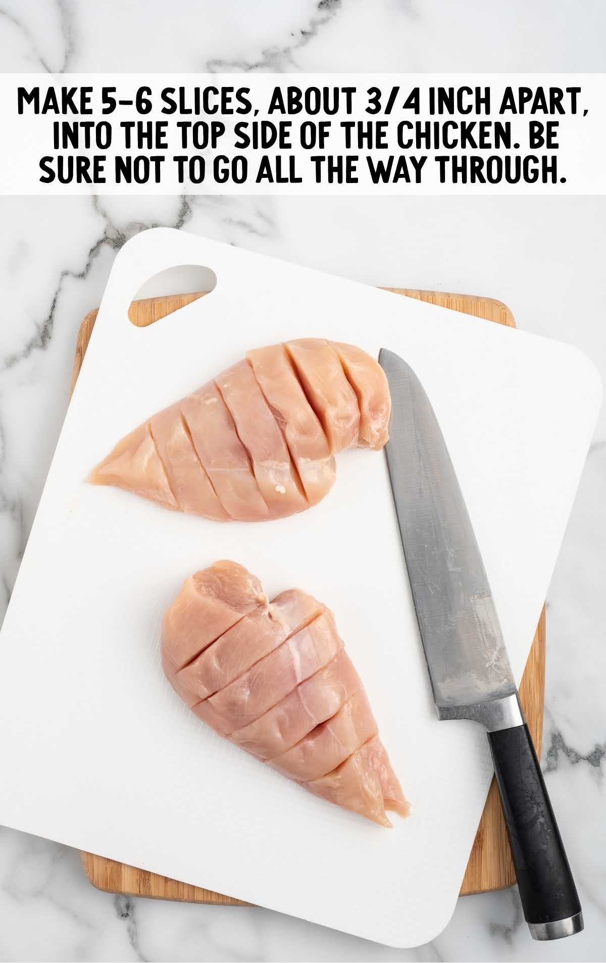 slices cut into the chicken breast on a wooden cutting board