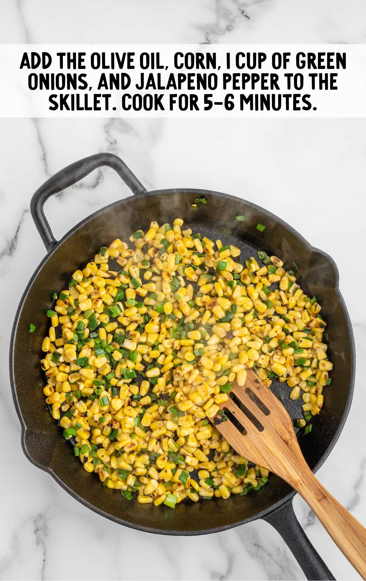 olive oil, corn, green onions, and diced jalapeño added to a skillet